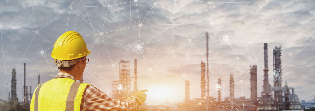 Industry worker pointing to ai generated network overlaying a industrial plant