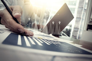 business person with laptop pointing at graph