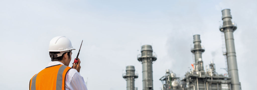 Engineer in uniform and helmet on of background the construction site power plant